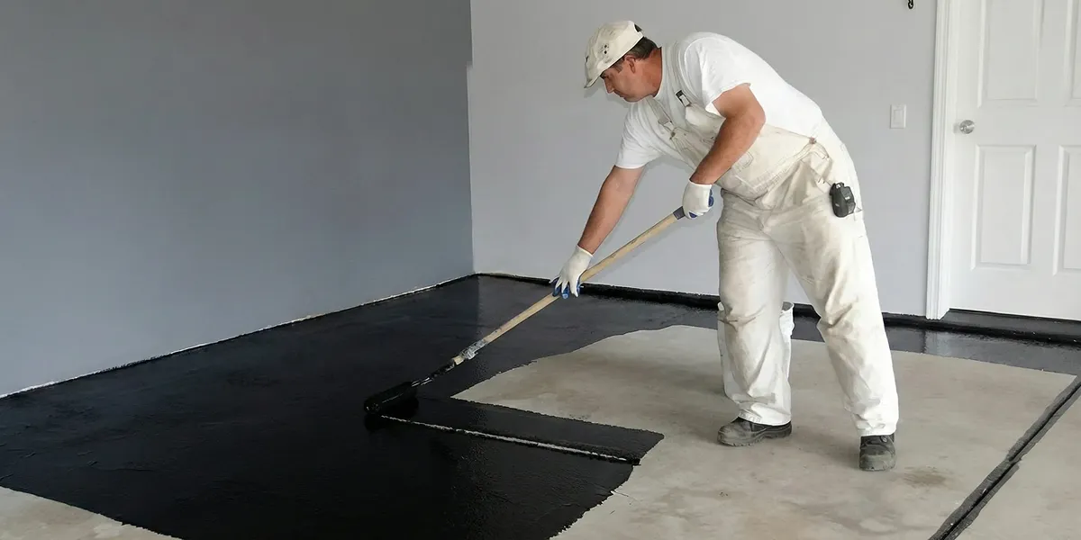 basement waterproofing professional applying waterproof coating to protect a basement floor in Columbia, SC