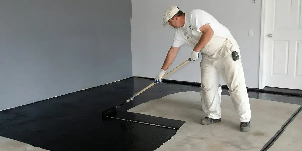 basement waterproofing professional applying waterproof coating to protect a basement floor in Columbia, SC